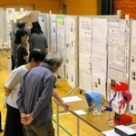 日ごろの疑問を児童生徒が調査し、成果をまとめた作品を見る来場者＝三木南交流センター