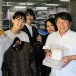播州織の製品を手にする小林郁香さん（左端）と高橋欣也さん（右端）＝小円織物