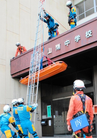 救助者役が乗った担架をつり下ろす訓練＝丹波市山南町谷川