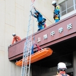 救助者役が乗った担架をつり下ろす訓練＝丹波市山南町谷川