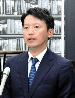 兵庫県知事選で当選確実となり、報道各社の取材に応じる斎藤元彦氏＝１７日深夜、神戸市中央区