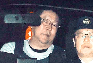 警察車両で送検される立花孝志容疑者（左）＝１０日午前９時４１分、神戸市中央区下山手通５