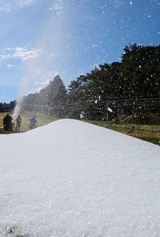 勢いよく噴き出し、ゲレンデを白く染めていく人工雪＝２３日午前、神戸市灘区六甲山町、六甲山スノーパーク（撮影・斎藤雅志）