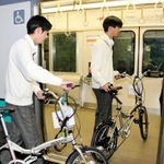 サイクルトレインの実証実験でＪＲ加古川線の車両に自転車を押して乗り込む高校生＝ＪＲ新西脇駅