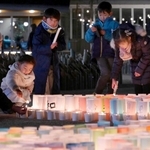 阪神・淡路大震災から１７日で２９年となる。神戸・三宮の東遊園地では発生半日前の１６日夕、数千本の明かりが黙とうをささげる人々を包んだ。灯籠でかたどられた文字は「ともに」。能登半島地震の被災地に寄り添う思いが込められた。消えた光を見て、再び火をともす子どもたちの姿も。亡き人への思いは、次代に引き継がれる＝１６日午後６時３２分、神戸市中央区加納町６（撮影・斎藤雅志）