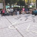 東日本大震災の発生時刻に合わせ、神戸で開かれた追悼行事。ろうそくで「３．１１　ともに」の文字を書いた＝１１日午後２時４６分、神戸市中央区加納町６（撮影・小林良多）