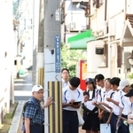 震災前から立つ路地の電柱を見学する舞子高校の生徒ら＝神戸市長田区長楽町３