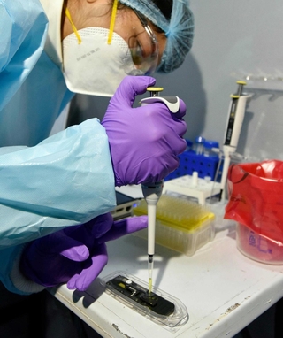 ニューデリーの研究所で行われたゲノム配列解析のデモンストレーション（ゲッティ＝共同）