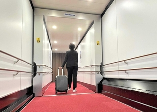 航空旅客搭乗橋「バリアフリータイプ」の開発のため、播磨工場に設けた試験機。通路左下の標準仕様ではレールなどが露出するが、右側はガーターレス機能のカバーで覆われている＝小野市匠台