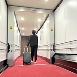 航空旅客搭乗橋「バリアフリータイプ」の開発のため、播磨工場に設けた試験機。通路左下の標準仕様ではレールなどが露出するが、右側はガーターレス機能のカバーで覆われている＝小野市匠台