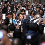 当選確実となった斎藤元彦氏（中央）にスマートフォンを向ける人たち＝２０２４年１１月１７日、神戸市中央区