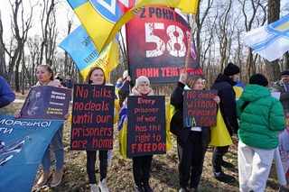 ６日、ウクライナ・キーウの米国大使館前で、対ロシア圧力強化を求めるデモに参加した女性ら（共同）