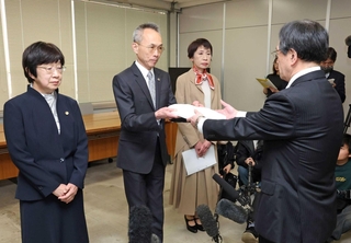 第三者調査委員会の調査報告書を受け取る小畑由起夫兵庫県代表監査委員（右）＝１９日午後、兵庫県庁