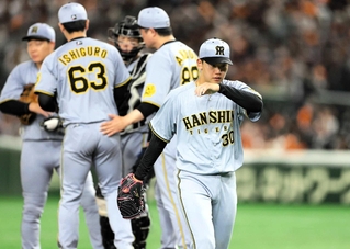 ４回、降板する阪神先発の門別（手前）