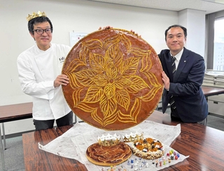 特大の「ガレット・デ・ロワ」を持つ兵庫県洋菓子協会の栗原栄徳副会長（左）ら＝神戸市中央区港島中町６