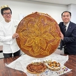 特大の「ガレット・デ・ロワ」を持つ兵庫県洋菓子協会の栗原栄徳副会長（左）ら＝神戸市中央区港島中町６