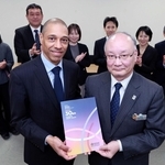 ＷＨＯ神戸センターが閉所に合わせて制作した記念誌を手にする同センターのロイック・ギャルソンさん（手前左）と兵庫県の山下輝夫保健医療部長（同右）＝兵庫県庁（撮影・鈴木雅之）