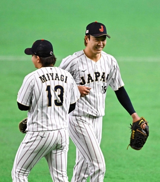 ５回途中、降板時に笑顔の高橋宏。左は宮城