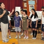 西灘小学校の児童に歌唱指導をする臼井真さん（左端）＝２０１４年１０月、神戸市灘区船寺通３