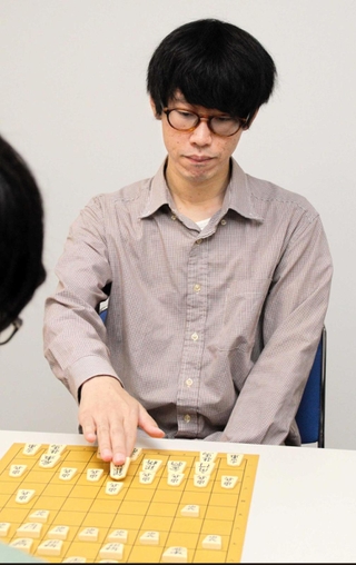 子どもと対局するアマ七段の慶田義法さん＝かこがわ将棋プラザ
