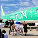 搭乗前、機体をバックに記念撮影する参加者ら＝神戸空港