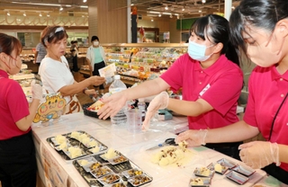ポリ袋で簡単に作れるレシピを実演し、食料備蓄の大切さを買い物客に呼びかける学生ら＝西区糀台５