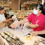 ポリ袋で簡単に作れるレシピを実演し、食料備蓄の大切さを買い物客に呼びかける学生ら＝西区糀台５