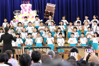 舞台上で元気な歌声を響かせる児童たち＝手柄小学校
