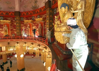 長いはたきを使ってほこりを取り除く職員ら＝姫路市名古山町