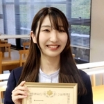 授業の空きこまに司法試験の勉強をしていた関学大の図書館で合格証書を持つ秋吉美帆さん＝西宮市上ケ原一番町