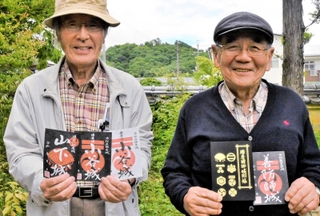 黒い和紙に朱色の家紋が入った新しいデザインの御城印。後方は小谷城跡＝加西市北条町北条、羅漢寺