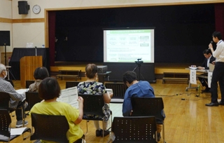 市民病院の跡地活用について、市の担当者（右）から基本方針案の説明を受ける参加者＝有馬富士共生センター