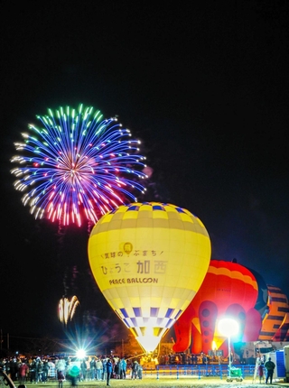 バーナーの炎で輝く気球が並び、花火が夜空を彩ったセント・バルーン・ナイト＝２０２１年、加西市鶉野町（市提供）