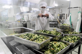 給食を作る様子を写真に撮る養父市学校給食センターの職員＝いずれも養父市小城