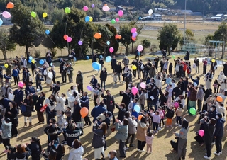 感謝の思いを乗せて風船を飛ばす参加者＝いずれも高平幼稚園