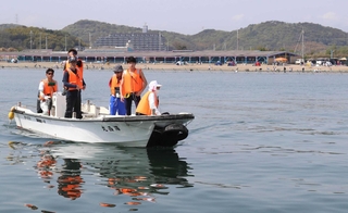 コース設定の準備をする大会関係者ら＝的形海水浴場沖