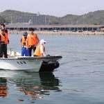 コース設定の準備をする大会関係者ら＝的形海水浴場沖