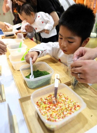 ７種類の材料を慎重に袋詰めする子どもたち＝三木市福井、道の駅みき