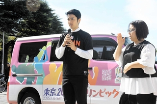 東京デフリンピックのキャラバンカー前で大会のＰＲと応援を呼びかけるバスケットボール競技日本代表の森井涼太選手（左）＝尼崎市役所
