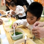 ７種類の材料を慎重に袋詰めする子どもたち＝三木市福井、道の駅みき