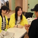 来場者に牛乳パックを使ったスプーンの作り方を教える甲南女子大の学生ら＝西宮市北口町