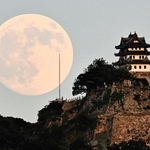 明るさの残る空に浮かぶ月と洲本城の模擬天守＝６日午後、洲本市物部１から撮影