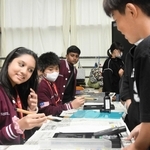 尼崎市立成徳小学校の授業に参加し、習字に挑戦するマレーシアの小学生ら＝尼崎市蓬川町