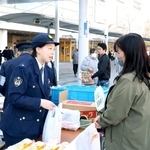 通行人らに卵などを配る明石署員（左）＝明石市大明石町１