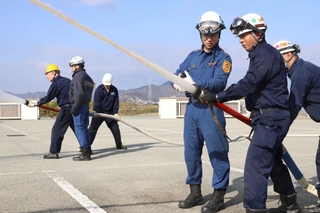 消防職員からホースの使い方を教わる訓練参加者＝加古川市防災センター