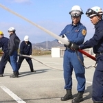 消防職員からホースの使い方を教わる訓練参加者＝加古川市防災センター