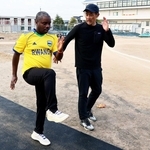 松岡紳介さん（右）から陸上のトレーニングについて教わるエマーブレ・ブレジェアさん＝明石北高校