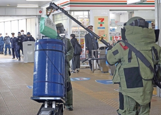 防護服を着た機動隊員が爆弾に見立てた紙袋を処理した＝高砂市神爪１