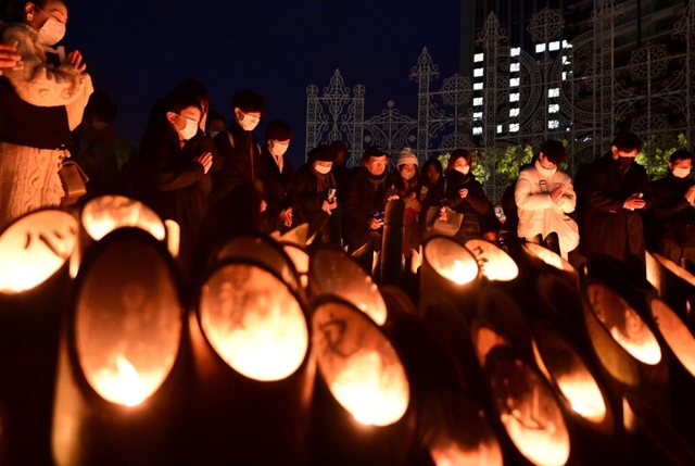 午後５時４６分の時報とともに黙とうする人たち＝１７日、神戸市中央区加納町６、東遊園地（撮影・中西幸大）