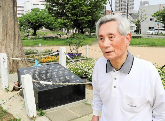 「千歳復興の礎」の前に立つ崔敏夫さん＝神戸市須磨区千歳町２
